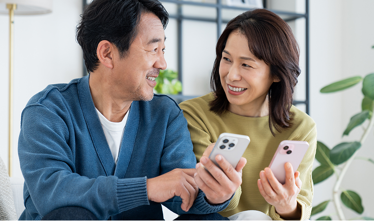 夫婦が携帯を触る写真